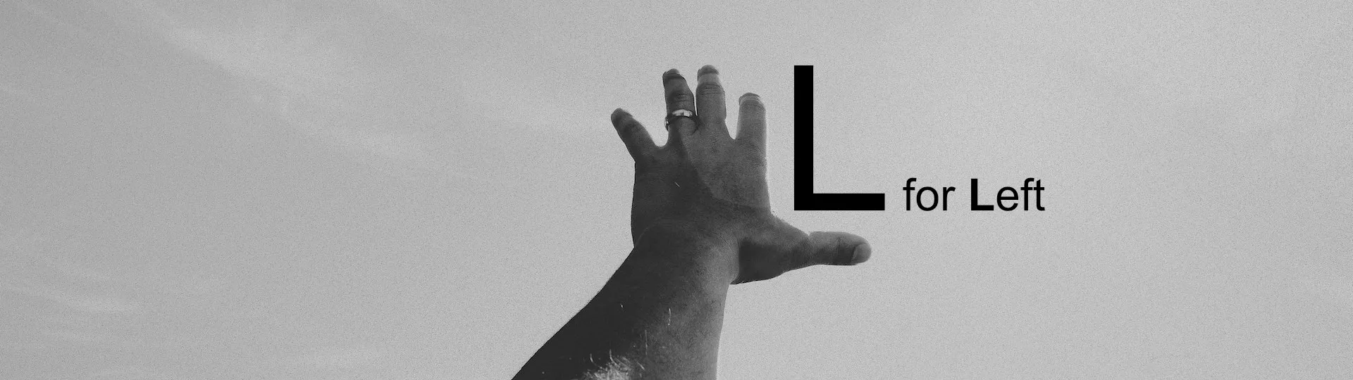 The back of a left hand with the thumb extended to make the letter L